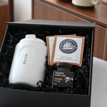 Gift set with a white personalised tumbler, tea bags, and honey in a black box