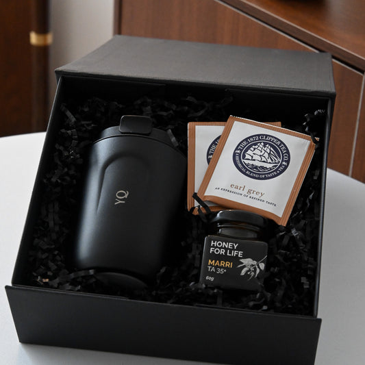 Gift set with a black personalised tumbler, tea bags, and honey in a black box